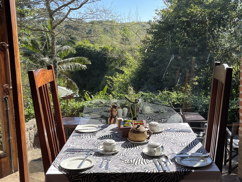 eettafel aan een groot raam met een mooi uitzicht op het groene landschap